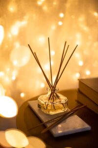 A decorative reed diffuser with a bokeh light background, creating a warm atmosphere.